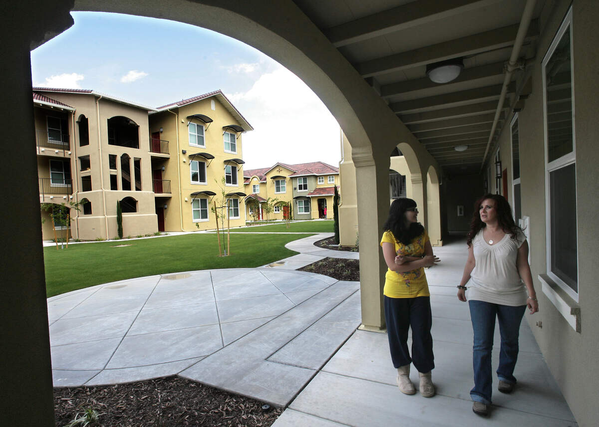 Christy Hall, right, and her 14-year-old daughter, Ivorie, take a break from unpacking after moving into their new two-bedroom apartment at Parc Grove Commons in Fresno in April 2011.